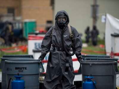 A U.S. Army Soldier with the 51st Chemical Biological Radiological Nuclear Company, of Fort Stewart, Georgia, stands watch at a decontamination field site at the Muscatatuck Urban Training Center, Indiana.