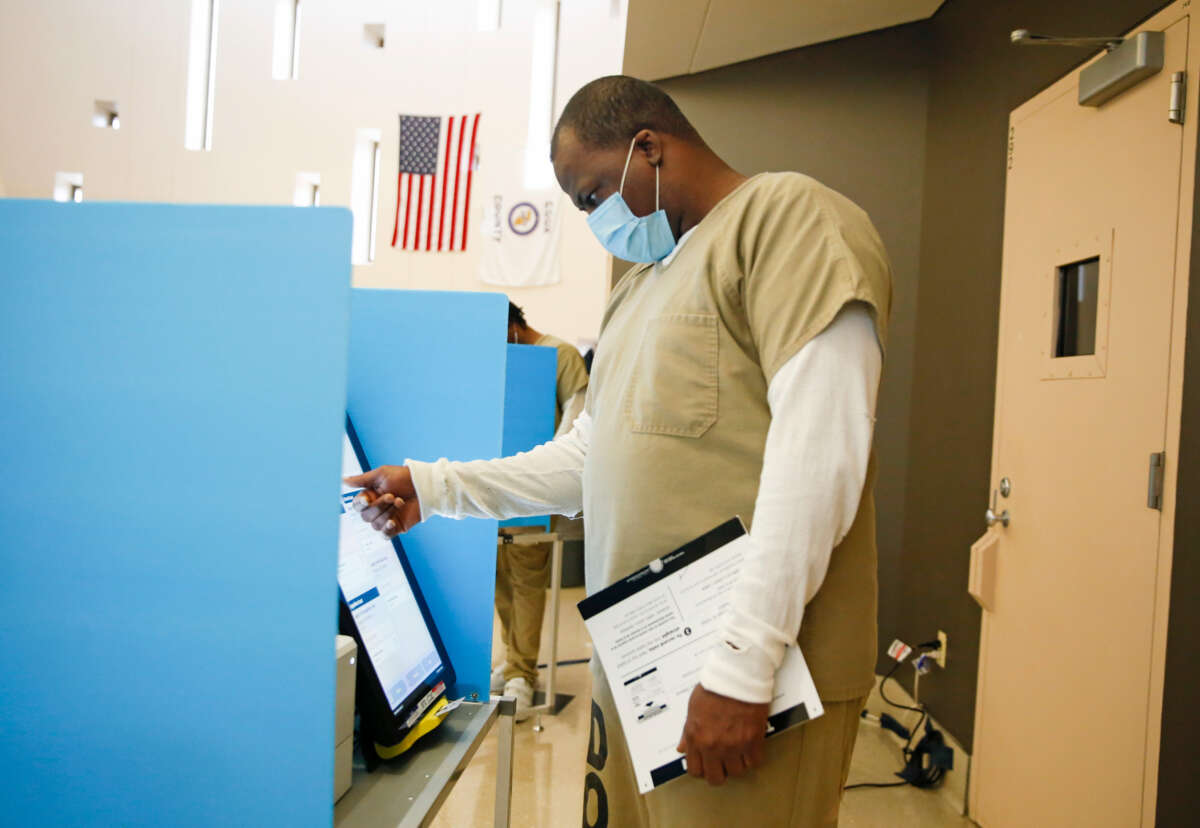 A prisoner votes at a booth