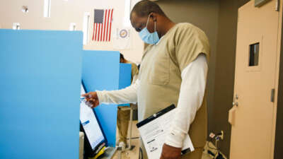 A prisoner votes at a booth