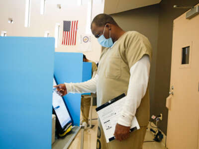 A prisoner votes at a booth