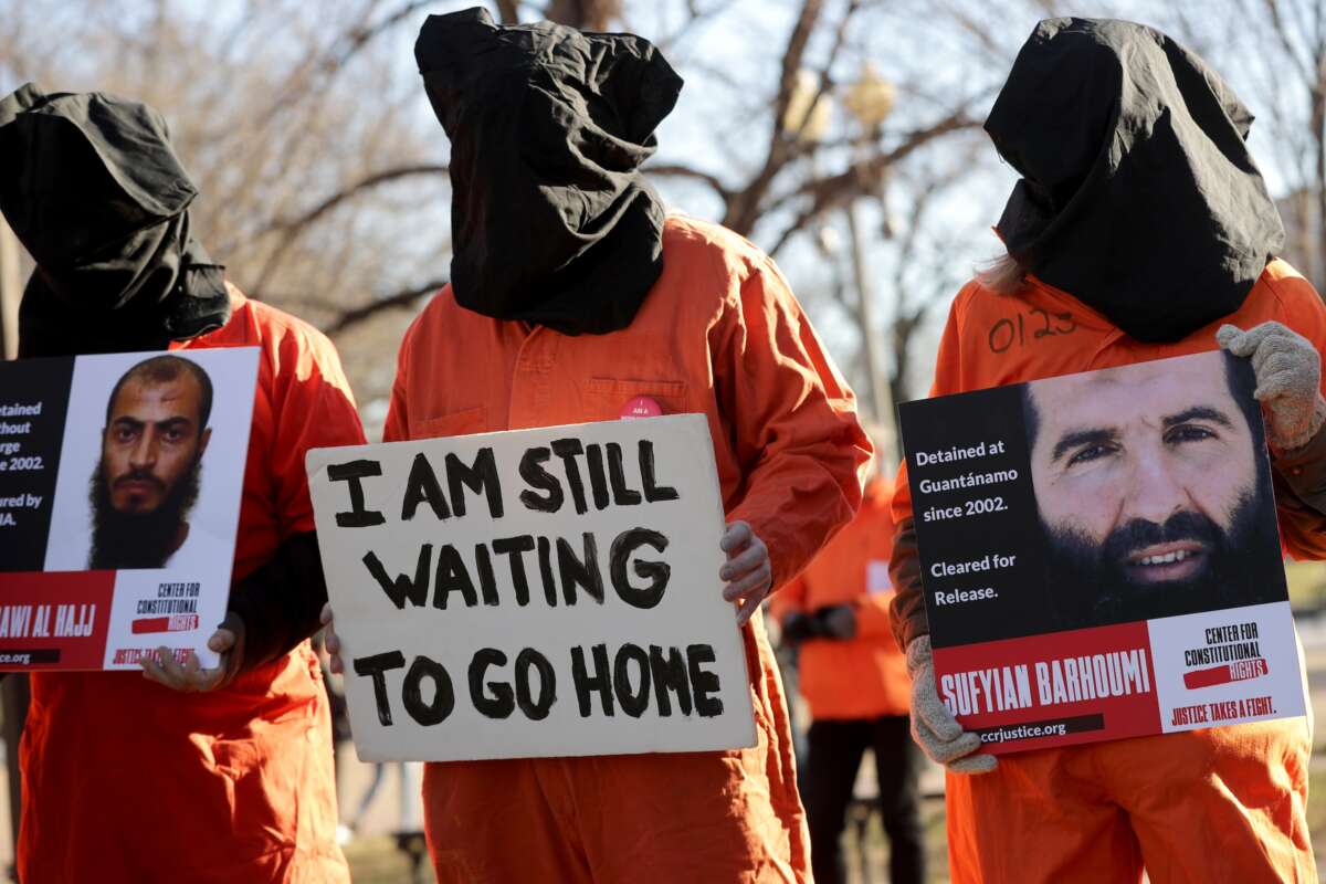 Demonstrators wearing orange jumpsuits and hoods over their heads rally to demand closure of the detention camp at the U.S. naval station in Guantánamo Bay, Cuba, outside the White House January 11, 2019, in Washington, DC.