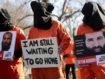 Demonstrators wearing orange jumpsuits and hoods over their heads rally to demand closure of the detention camp at the U.S. naval station in Guantánamo Bay, Cuba, outside the White House January 11, 2019, in Washington, DC.