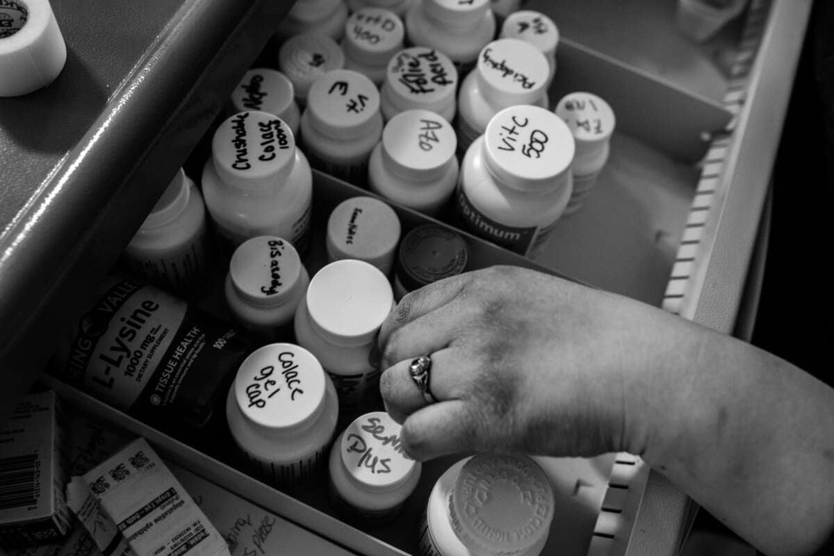 Johanna Meneses, 32, grabs over the counter medications for her patients at Twilight Gardens nursing home in Norwalk, Ohio, on March 4, 2023.