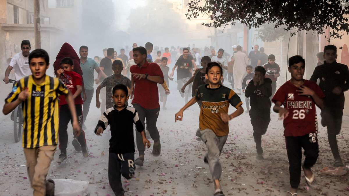 Palestinian children flee from Israeli bombardment in Rafah in the southern Gaza Strip on November 6, 2023.