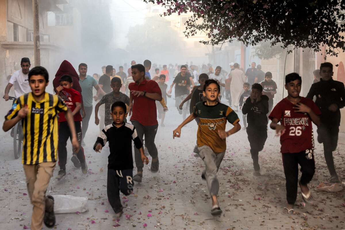 Palestinian children flee from Israeli bombardment in Rafah in the southern Gaza Strip on November 6, 2023.