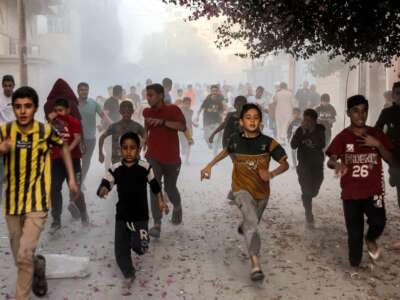 Palestinian children flee from Israeli bombardment in Rafah in the southern Gaza Strip on November 6, 2023.