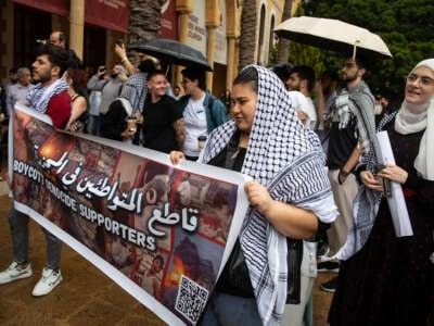 Students at the American University of Beirut hold up a sign demanding a boycott of companies working in Israel while protesting the genocide in Gaza on April 30, 2024, in Beirut, Lebanon.