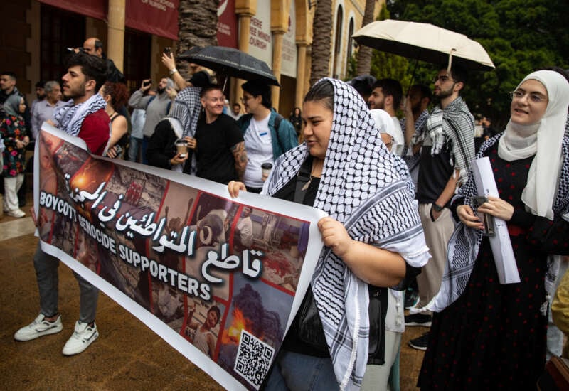 Students at the American University of Beirut hold up a sign demanding a boycott of companies working in Israel while protesting the genocide in Gaza on April 30, 2024, in Beirut, Lebanon.