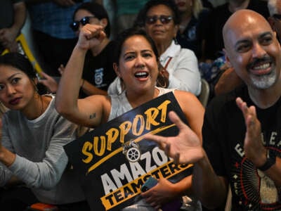 An attendee holds a Support Amazon Teamsters sign during a rally with workers and union members as part of an "Amazon Teamsters Day of Solidarity" in support of the unionization and collective bargaining of Amazon delivery drivers at the Teamsters Local 848 on August 29, 2024, in Long Beach, California.