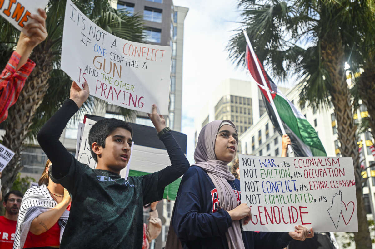 Pro-Palestinian protesters hold signs as people rally in support of Gaza and Lebanon in front of the City Hall in Orlando, Florida, on October 5, 2024.