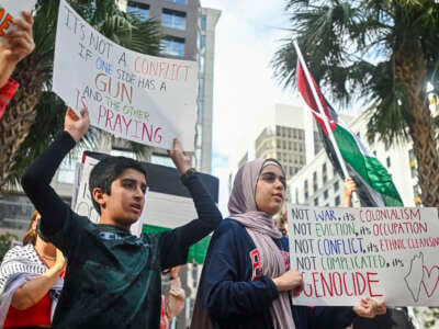 Pro-Palestinian protesters hold signs as people rally in support of Gaza and Lebanon in front of the City Hall in Orlando, Florida, on October 5, 2024.