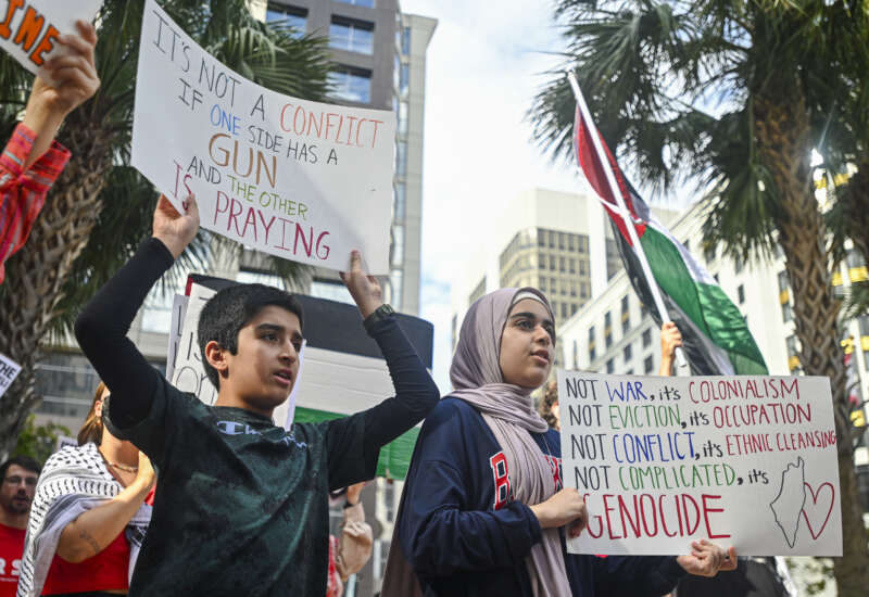 Pro-Palestinian protesters hold signs as people rally in support of Gaza and Lebanon in front of the City Hall in Orlando, Florida, on October 5, 2024.