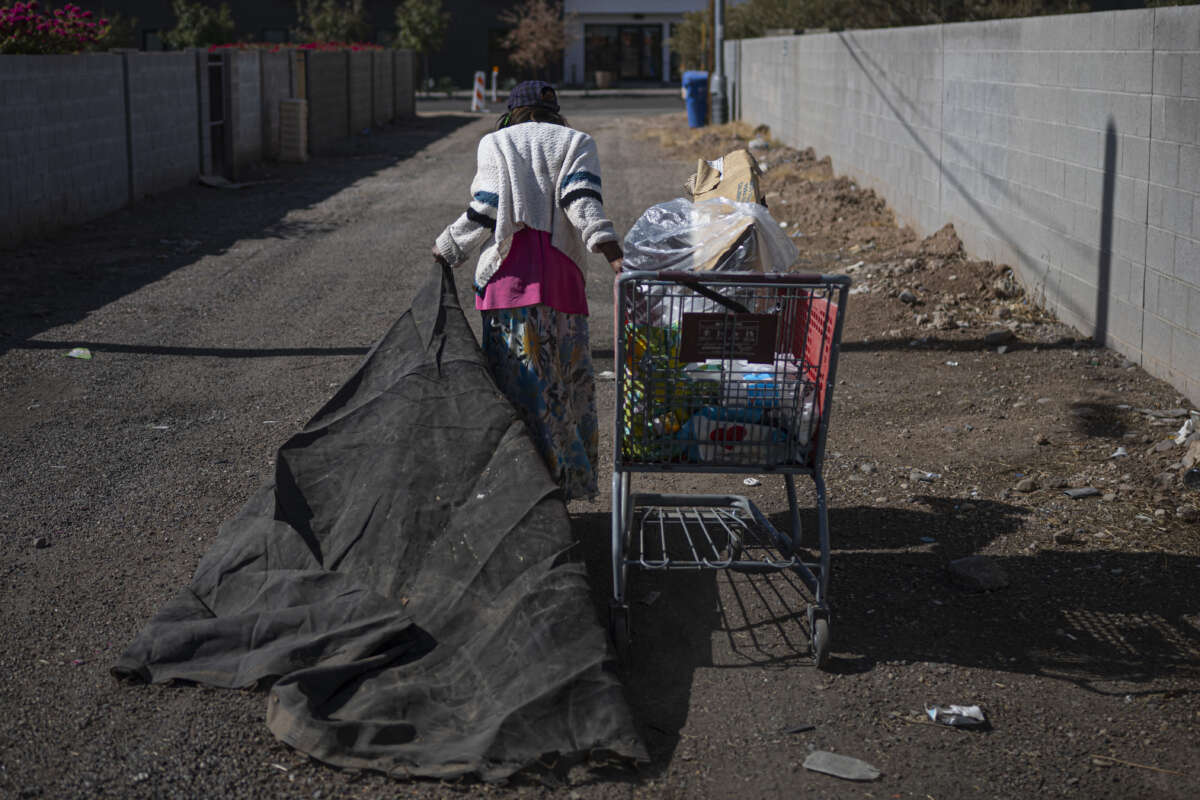 A homeless woman carries her personal belongings in Phoenix, Arizona, on November 3, 2024.