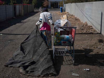 A homeless woman carries her personal belongings in Phoenix, Arizona, on November 3, 2024.