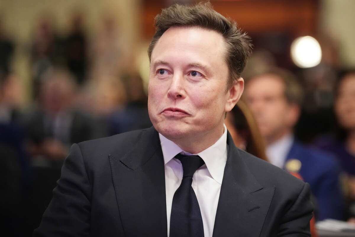 Elon Musk listens as President-elect Donald Trump addresses a House Republicans Conference meeting at the Hyatt Regency on Capitol Hill on November 13, 2024, in Washington, D.C.