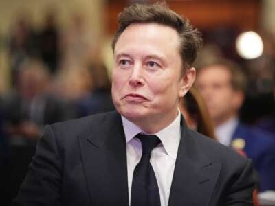 Elon Musk listens as President-elect Donald Trump addresses a House Republicans Conference meeting at the Hyatt Regency on Capitol Hill on November 13, 2024, in Washington, D.C.