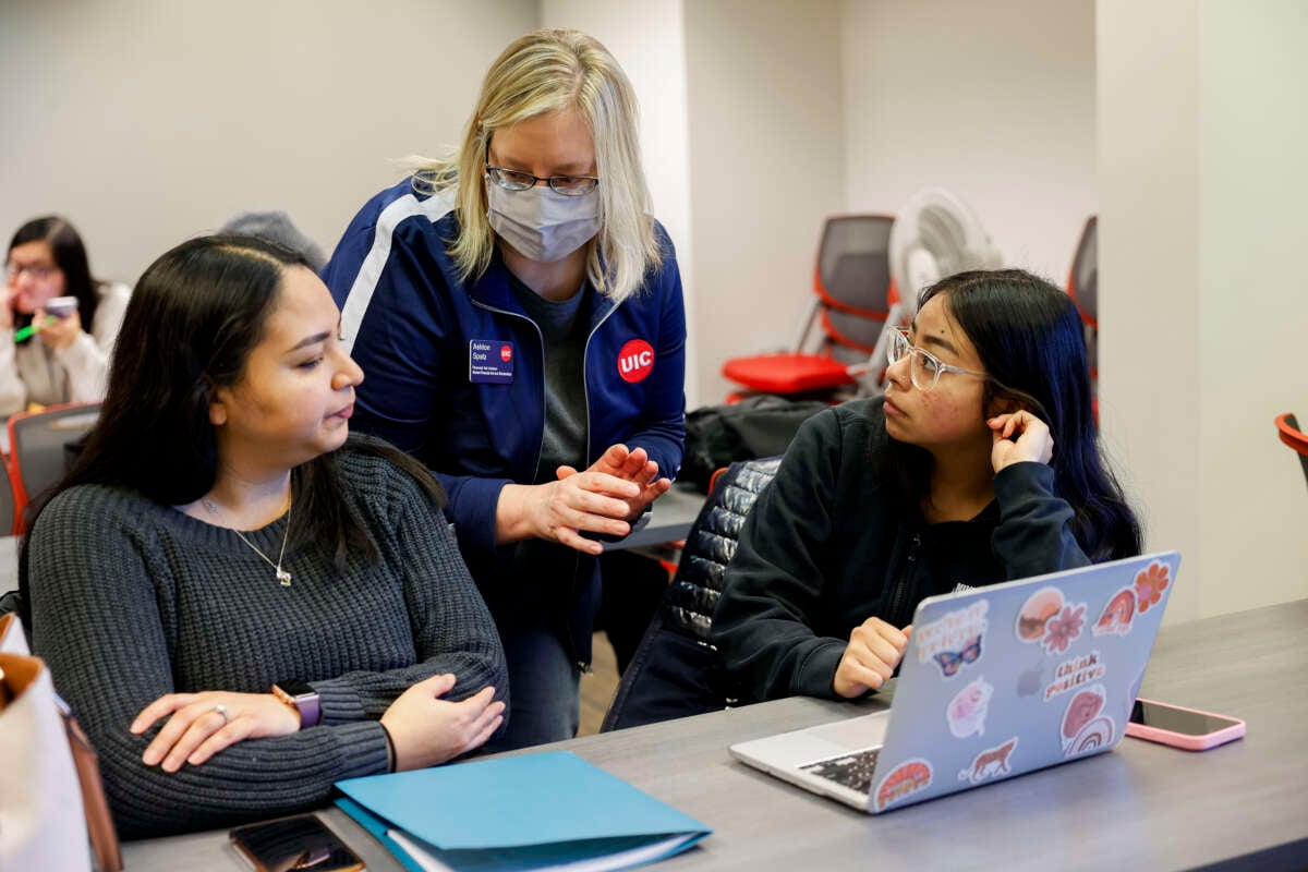 Ashton Spatz, center, a financial aid adviser with the University of Illinois Chicago (UIC), assists a mother and daughter during a FAFSA workshop on February 23, 2024, at UIC's Student Financial Aid Office in Chicago, Illinois.