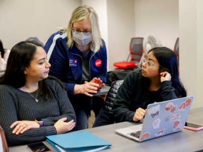 Ashton Spatz, center, a financial aid adviser with the University of Illinois Chicago (UIC), assists a mother and daughter during a FAFSA workshop on February 23, 2024, at UIC's Student Financial Aid Office in Chicago, Illinois.