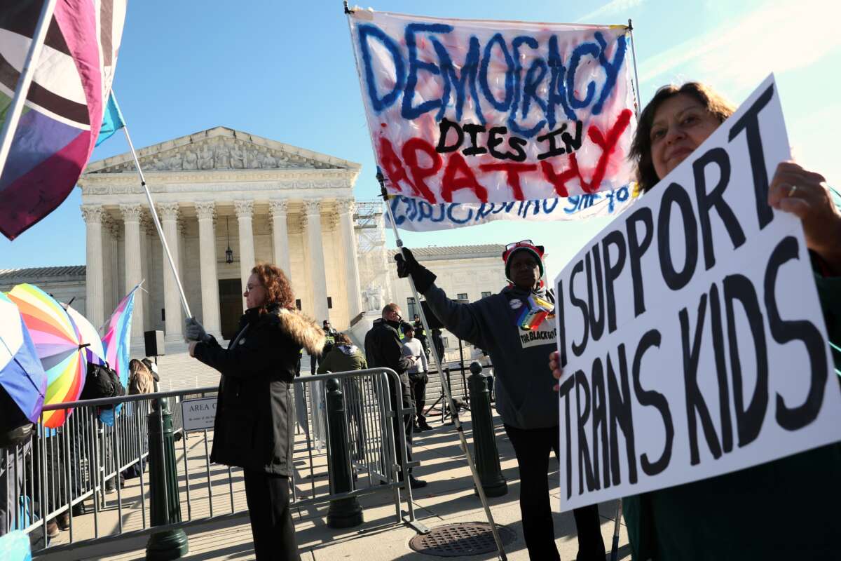 Trans rights supporters rally outside of the U.S. Supreme Court as the high court hears arguments in a case on transgender health rights on December 4, 2024, in Washington, D.C.