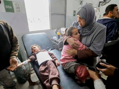 A mother holds her injured child close at Al Awda Hospital in Nuseirat, Gaza, on December 17, 2024.