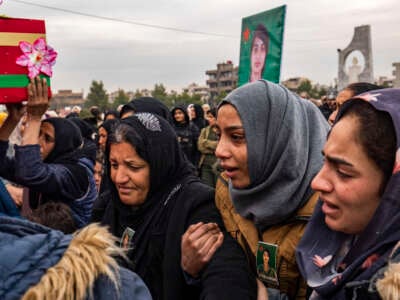 People mourn during the funeral procession of a member of the Women's Protection Units (YPJ), who was killed during a Turkish drone strike in the countryside of Kobani a day earlier, in Syria's northeastern city of Qamishli, on December 22, 2024.