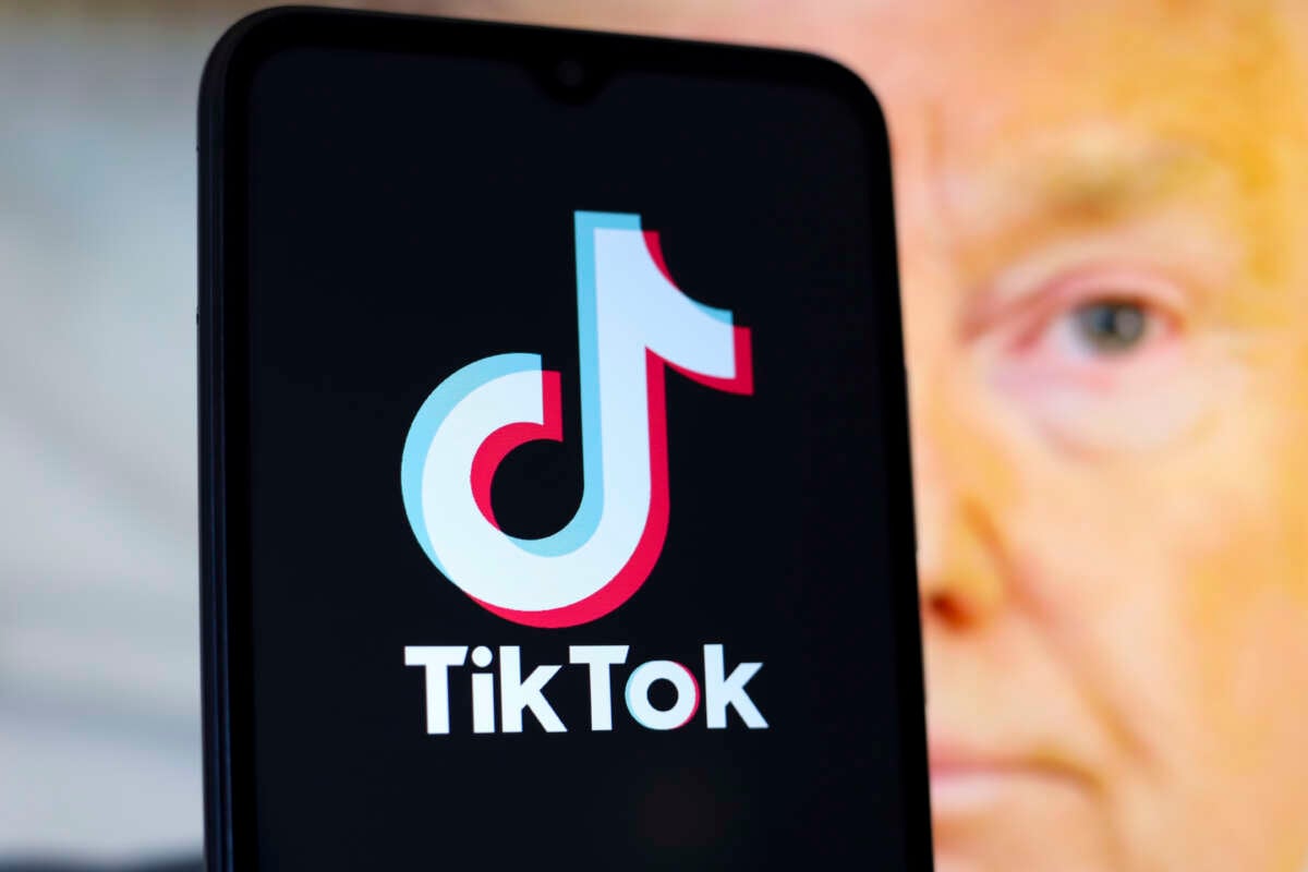 The TikTok logo appears on a smartphone screen with a photo of Donald Trump in the background, in this illustration photo from December 28, 2024.