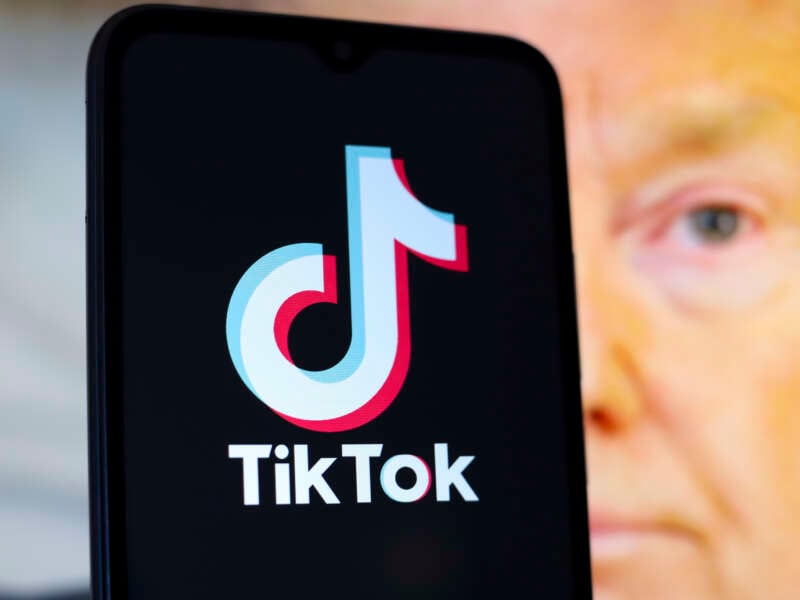 The TikTok logo appears on a smartphone screen with a photo of Donald Trump in the background, in this illustration photo from December 28, 2024.