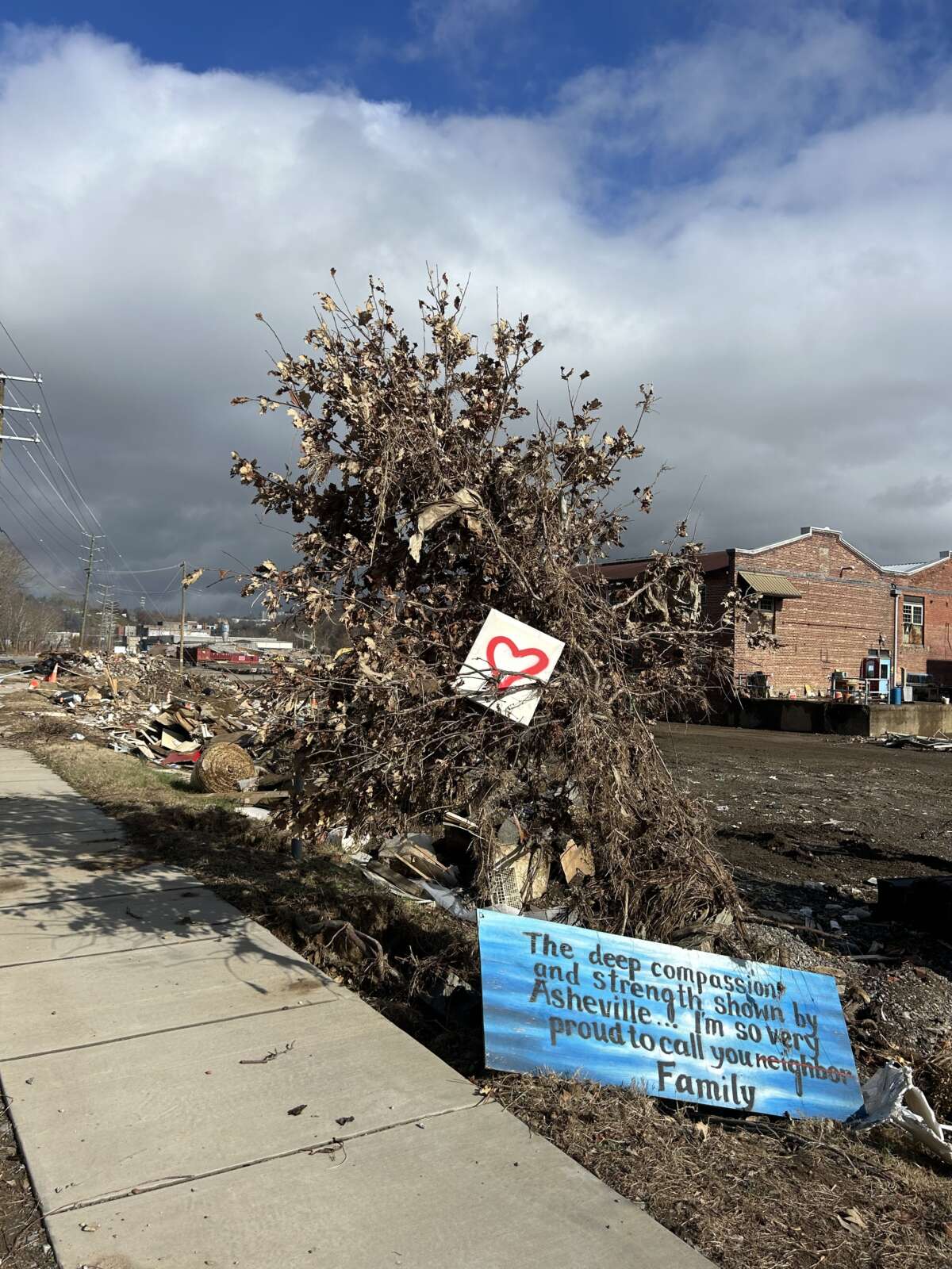 Someone left a message for neighbors in the River Arts District of Asheville, North Carolina, taken on November 28, 2024. It reads: "The deep compassion and strength shown by Asheville ... I'm so very proud to call you neighbor Family."