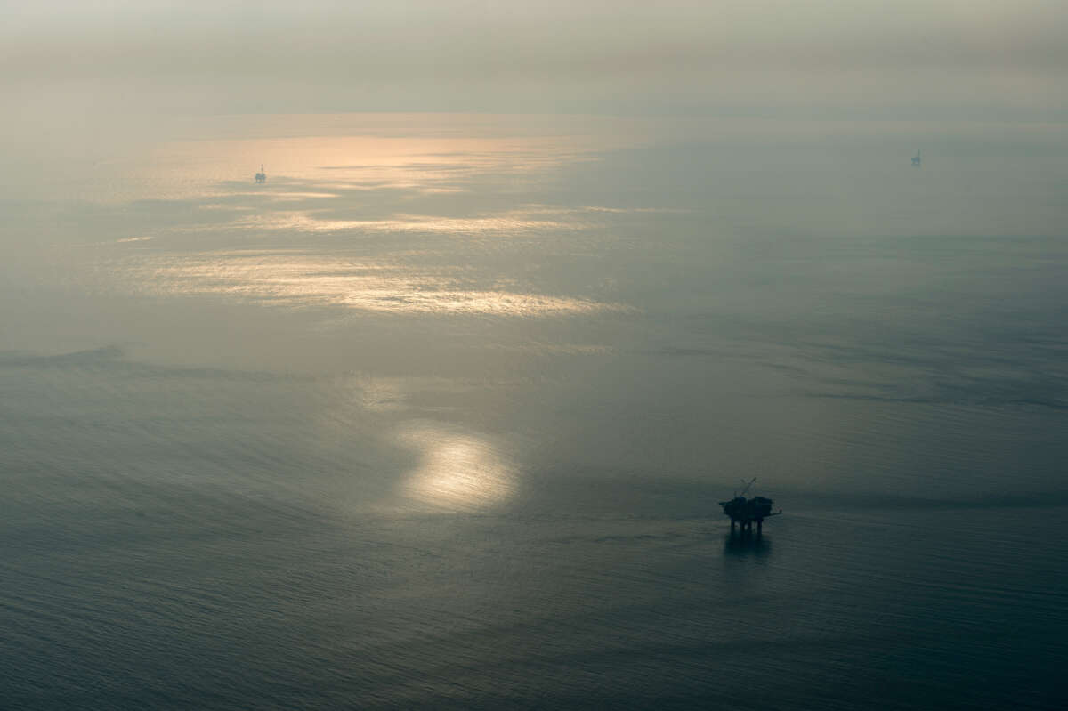 Oil Rigs are seen through the smoke of wildfires exacerbated by the existence of oil rigs