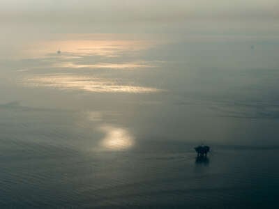 Oil Rigs are seen through the smoke of wildfires exacerbated by the existence of oil rigs