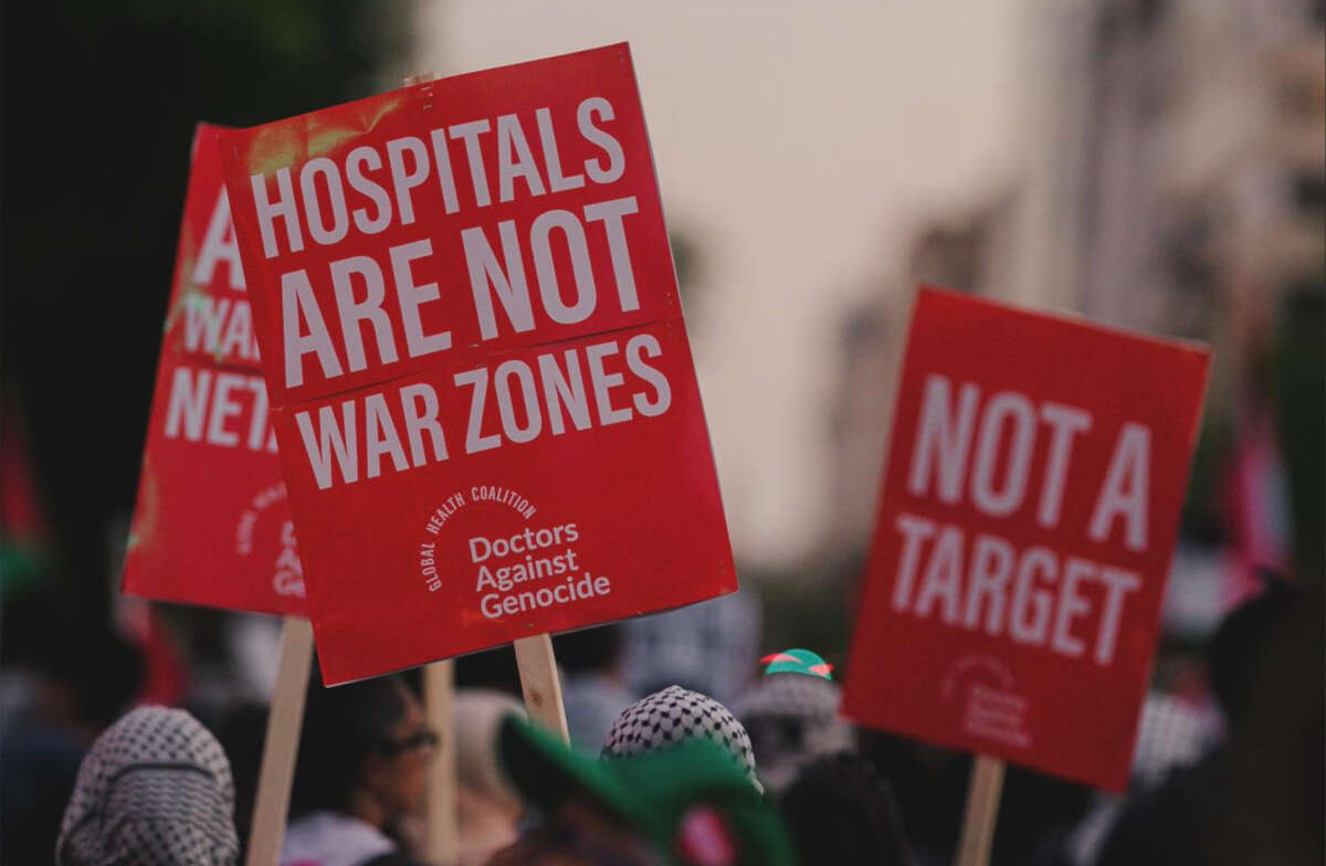 Signs reading 'hospitals are not war zones' and 'not a target' at a protest held by Doctors Against Genocide in October, 2024.