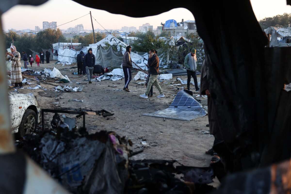 Displaced Palestinians walk amid scattered debris of tents on January 2, 2025, following an overnight Israeli strike on a makeshift displacement camp in Mawasi Khan Yunis in the southern Gaza Strip, that reportedly killed at least 11 people, including the chief of the territory's now dismantled Hamas police force.