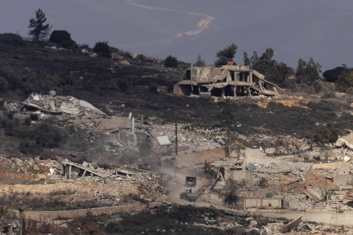 Israeli army vehicles move in a village in southern Lebanon as seen from a position on the Israeli side of the border on January 23, 2025.