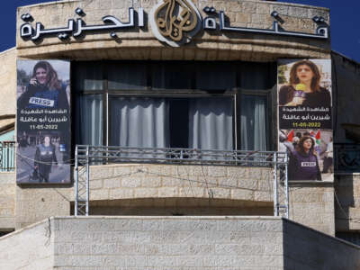 Pictures of slain Palestinian journalist Shireen Abu Akleh are hung across the facade of the building housing the Doha-based Al-Jazeera TV channel in the occupied-West Bank city of Ramallah on January 2, 2025.