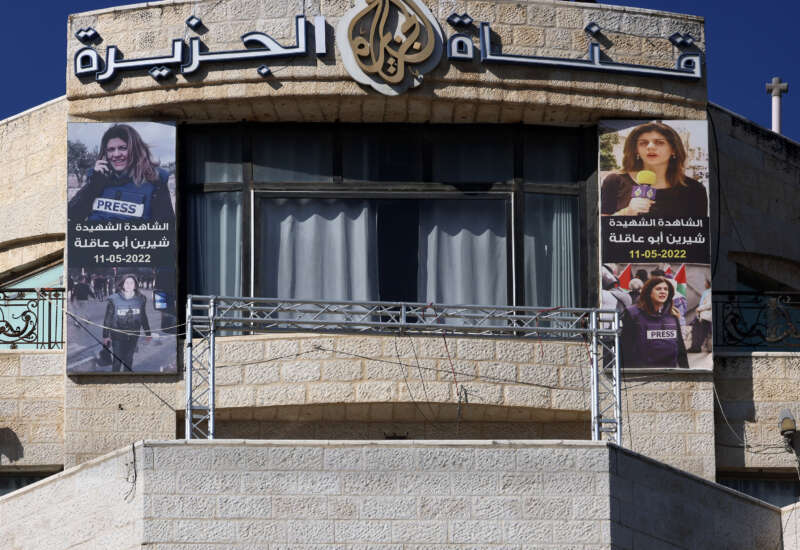 Pictures of slain Palestinian journalist Shireen Abu Akleh are hung across the facade of the building housing the Doha-based Al-Jazeera TV channel in the occupied-West Bank city of Ramallah on January 2, 2025.