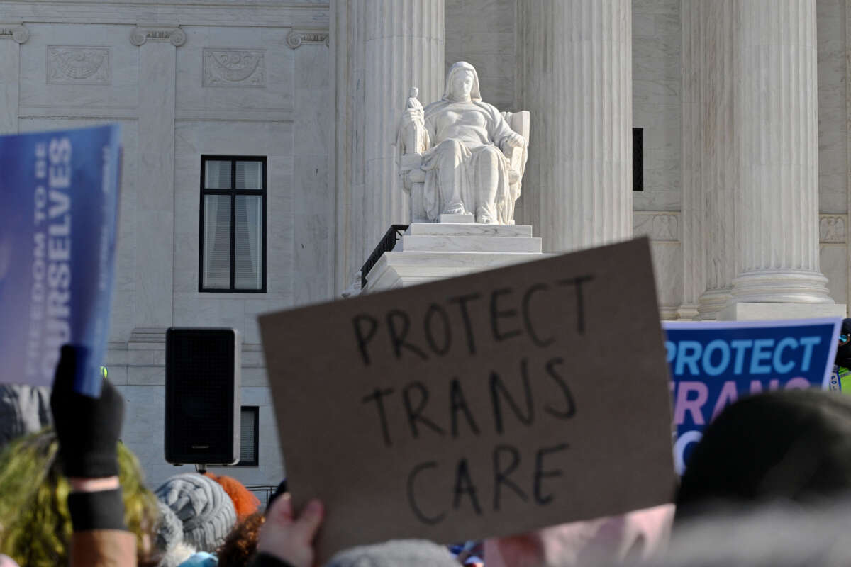 People hold signs outside the Supreme Court on December 4, 2024, in Washington, D.C, during oral arguments on whether states can ban certain gender-affirming care for young people.