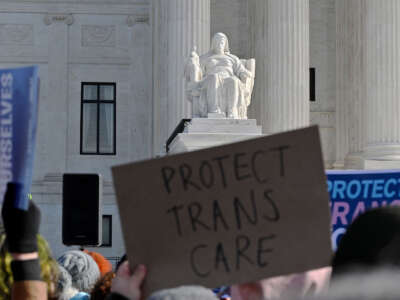 People hold signs outside the Supreme Court on December 4, 2024, in Washington, D.C, during oral arguments on whether states can ban certain gender-affirming care for young people.