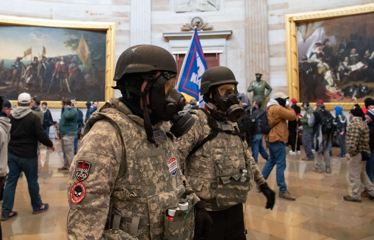 Supporters of President Donald Trump wear gas masks and military-style apparel as they walk around inside the Rotunda after breaching the US Capitol in Washington, D.C., on January 6, 2021.