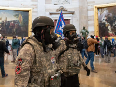 Supporters of President Donald Trump wear gas masks and military-style apparel as they walk around inside the Rotunda after breaching the US Capitol in Washington, D.C., on January 6, 2021.