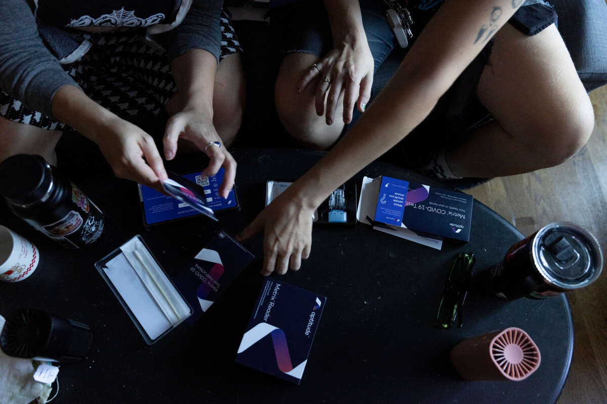 People read directions for a home PCR Covid test in an apartment in Atlanta, Georgia, on August 31, 2024.