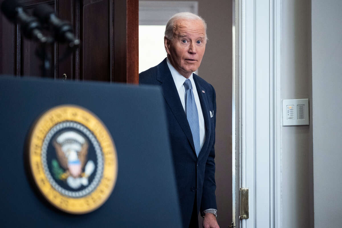 Joe Biden, looking surprised at something, exits through a door