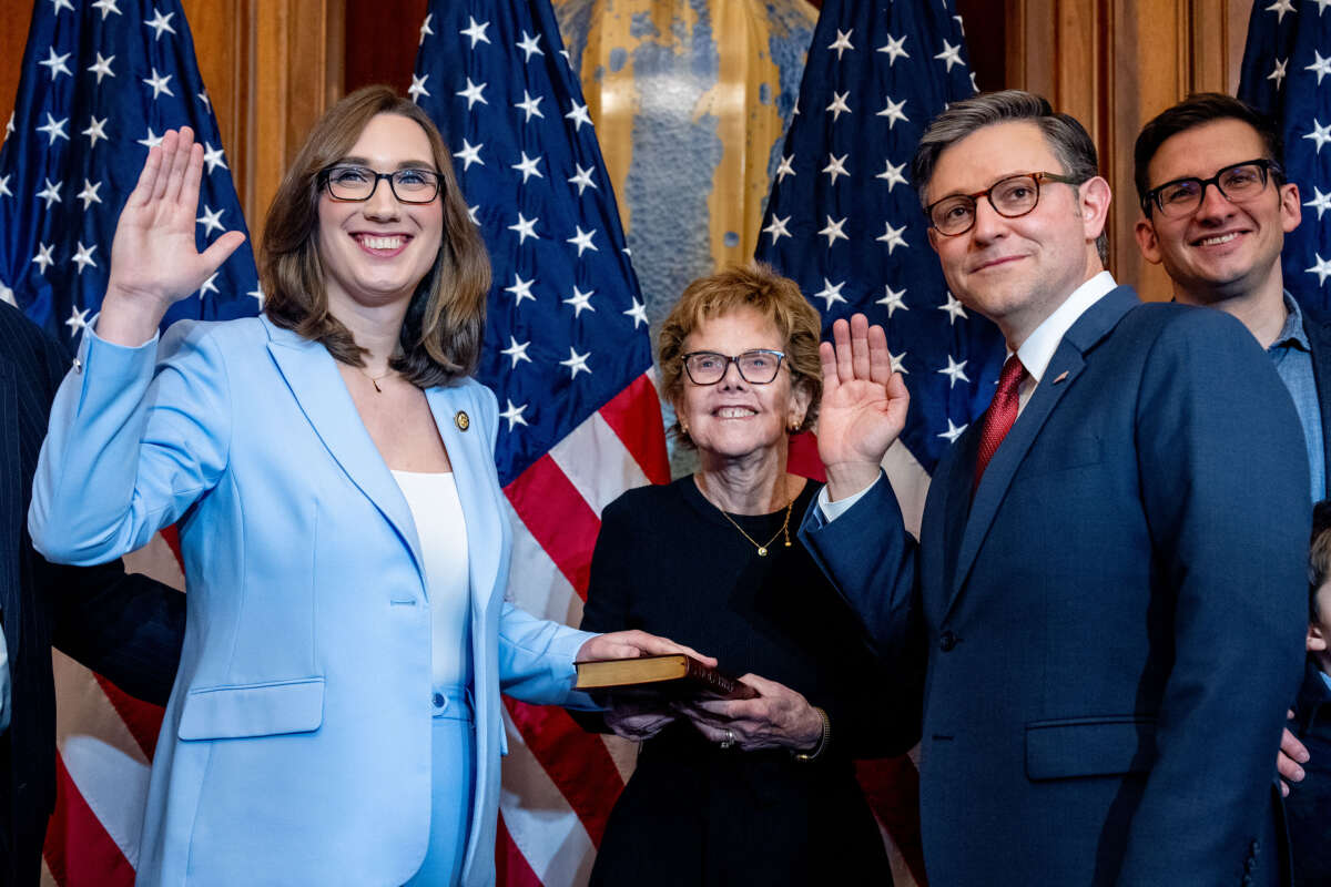 Speaker of the House Mike Johnson poses with Rep. Sarah McBride and members of McBride's family during a ceremonial swearing-in photo after being re-elected Speaker on the first day of the 119th Congress in the U.S. Capitol Building on January 3, 2025, in Washington, D.C.