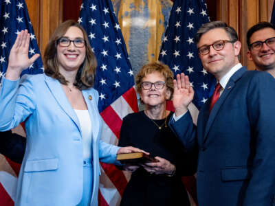 Speaker of the House Mike Johnson poses with Rep. Sarah McBride and members of McBride's family during a ceremonial swearing-in photo after being re-elected Speaker on the first day of the 119th Congress in the U.S. Capitol Building on January 3, 2025, in Washington, D.C.