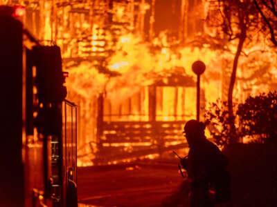 Firefighters battle the Eaton Fire in strong winds as many homes burn on January 7, 2025, in Pasadena, California.