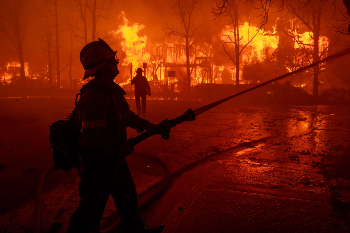 Firefighters battle the Eaton Fire in strong winds as many homes burn on January 7, 2025, in Pasadena, California.