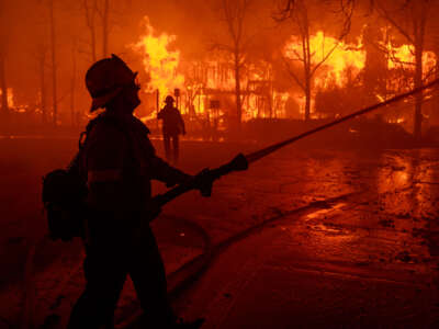 Firefighters battle the Eaton Fire in strong winds as many homes burn on January 7, 2025, in Pasadena, California.