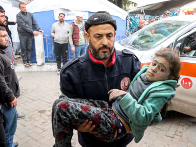 A man carries a girl that was rescued from the rubble of a collapsed building to receive medical care at the Ahli Arab hospital, also known as the Baptist hospital, in Gaza City on January 4, 2025.