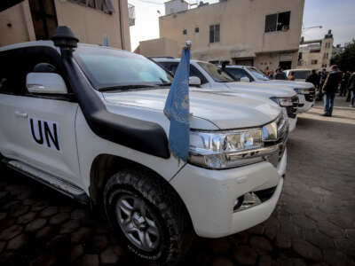 A United Nations vehicle with a blue flag is parked on a cobblestone street in Gaza on December 11, 2024.