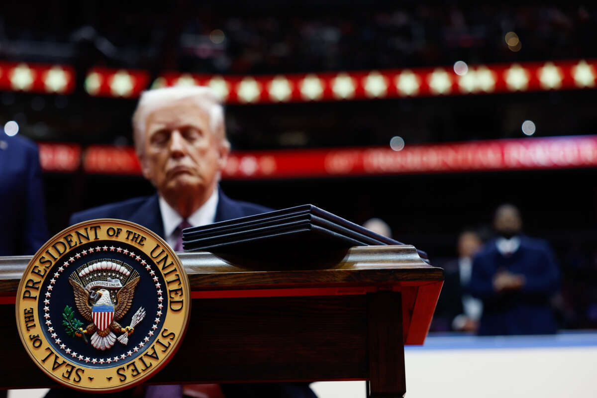 President Donald Trump signs executive orders during an indoor inauguration parade at Capital One Arena on January 20, 2025, in Washington, D.C.