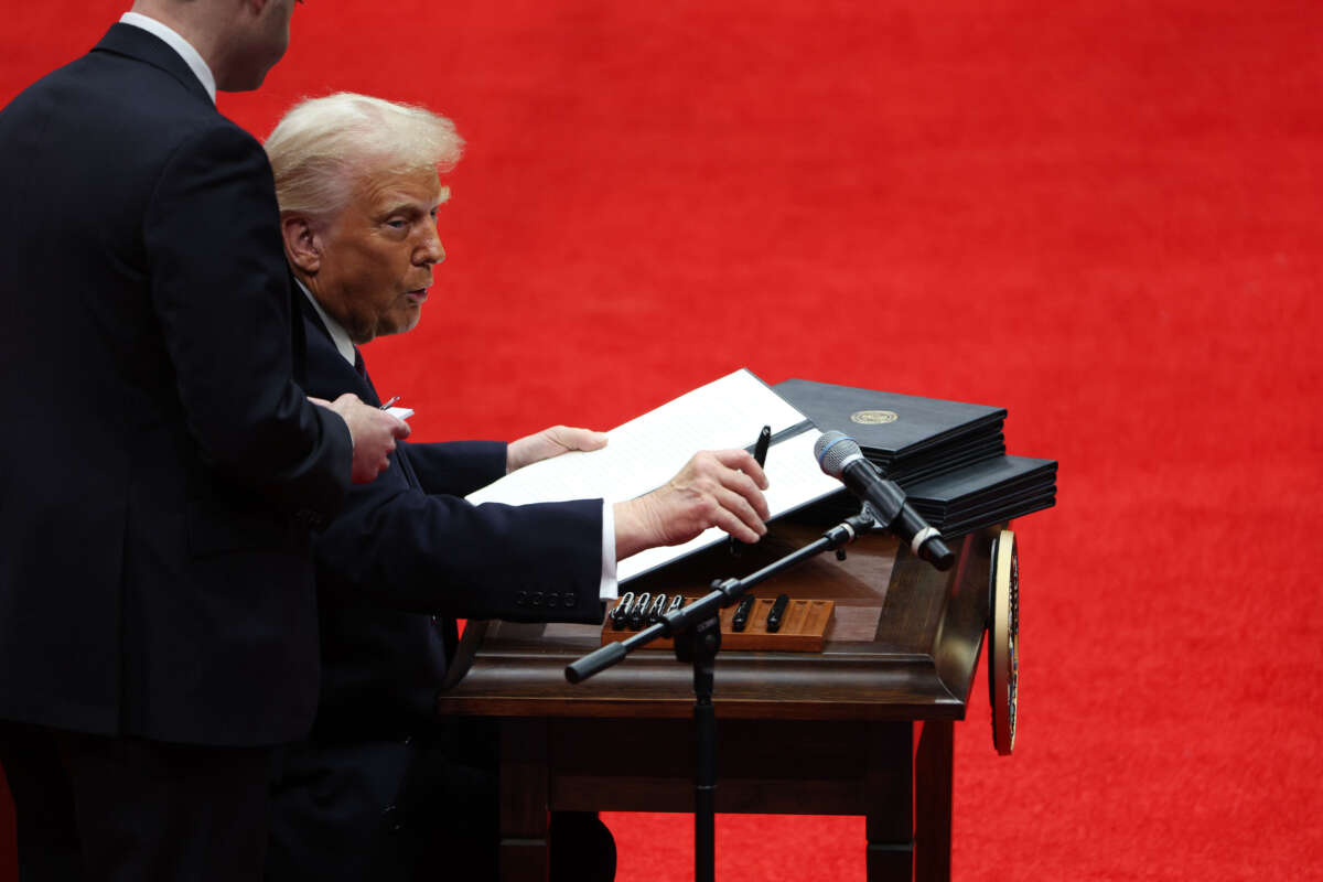 President Donald Trump signs executive orders during an indoor inauguration parade at Capital One Arena on January 20, 2025, in Washington, D.C.